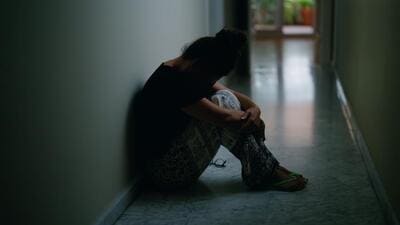 Middle age hispanic woman suffering for domestic violence with bruise on eyes sitting on floor at home Middle age hispanic woman suffering for domestic violence with bruise on eyes sitting on floor at home