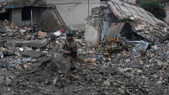 An Iraqi soldier stands guard at the site of a destroyed healthcare center in the Habbaniyah military base, which was targeted by in an airstrike killing seven security personnel and wounding 13 others, in Habbaniyah, west of Baghdad on March 26, 2026. (AFP)