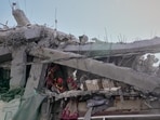 First responders inspect a residential building hit in an earlier U.S.-Israeli strike in Tehran, Friday, March 27, 2026. 