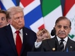 US President Donald Trump looks at Pakistan's Prime Minister Shehbaz Sharif speaking following the official signing of the first phase of the Gaza ceasefire agreement between Israel and Hamas.