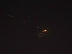 Rocket trails are seen in the sky amid a fresh barrage of Iranian missile attacks above the Israeli coastal city of Netanya on March 27, 2026. 