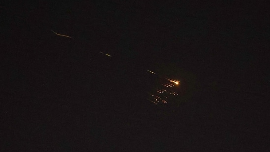 Rocket trails are seen in the sky amid a fresh barrage of Iranian missile attacks above the Israeli coastal city of Netanya on March 27, 2026. (AFP)