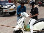 An EV scooterist with diesel filled in a plastic container. (HT Photo)