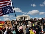 A demonstrator holds an upside-down American flag during a "No Kings" protest in front of the Lincoln Memorial