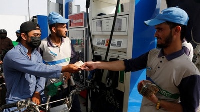 Malik Mohsin Ali, a rider for Bykea, ride-hailing and delivery platform, pays for fuel at a petrol station in Karachi, Pakistan, March 18, 2026. REUTERS/Asim Hafeez (REUTERS)
