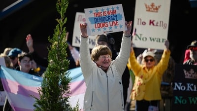 Demonstrators hold signs and cheer by the roadside as a part of a No Kings protest on March 28, 2026 in Shelbyville, Kentucky. (Getty Images via AFP) Demonstrators hold signs and cheer by the roadside as a part of a No Kings protest on March 28, 2026 in Shelbyville, Kentucky. (Getty Images via AFP)