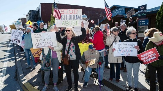 Demonstrators hold signs and cheer by the roadside as a part of a No Kings protest on March 28, 2026 in Shelbyville, Kentucky.(Getty Images via AFP)