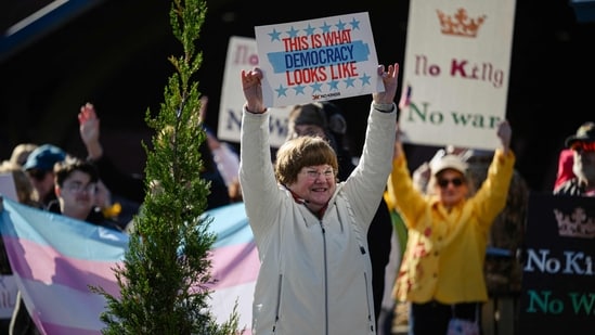Demonstrators hold signs and cheer by the roadside as a part of a No Kings protest on March 28, 2026 in Shelbyville, Kentucky.&nbsp;(Getty Images via AFP)
