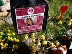 Flowers and signs are seen in a makeshift memorial in front of the home of Nancy Guthrie on February 27, 2026 in Tucson