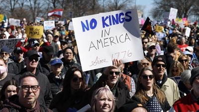 People hold signs as they rally at Grant Park during the "No Kings" national day of protest in Chicago on March 28, 2026. (Photo by KAMIL KRZACZYNSKI / AFP) (AFP) People hold signs as they rally at Grant Park during the "No Kings" national day of protest in Chicago on March 28, 2026. (Photo by KAMIL KRZACZYNSKI / AFP) (AFP)