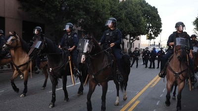 LAPD mounted police officers evacuate the area following clashes near the Metropolitan Detention Center during the "No Kings" national day of protest in Los Angeles on March 28, 2026. (Photo by Etienne Laurent / AFP) (AFP) LAPD mounted police officers evacuate the area following clashes near the Metropolitan Detention Center during the "No Kings" national day of protest in Los Angeles on March 28, 2026. (Photo by Etienne Laurent / AFP) (AFP)
