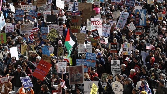 TOPSHOT - People hold signs and flags as they march during the "No Kings" national day of protest in Chicago on March 28, 2026. (Photo by KAMIL KRZACZYNSKI / AFP)(AFP)
