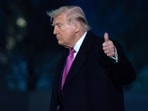 President Donald Trump waves to the media as he walks on the South Lawn upon his arrival at the White House, Sunday in Washington.