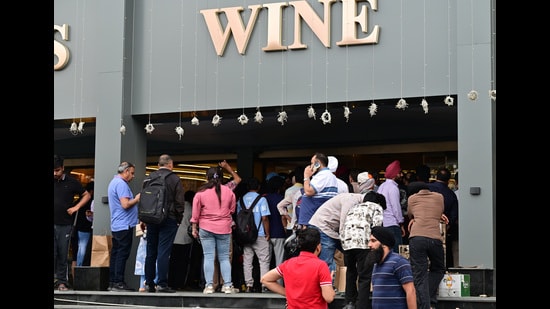 Long queues were seen at liquor stores on Tuesday as vendors offered booze at almost half rates or even less as they cleared the stock before the onset of the new financial year. (Ravi Kumar/HT)