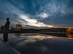 People are seen under cloud-laden skies during a pleasant evening at Bharat Mandapam in New Delhi, India.