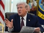 President Donald Trump answers questions from reporters after signing an executive order in the Oval Office of the White House.
