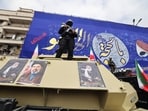 Members of the security forces stand guard on armoured vehicles plastered with portraits of Ali Khamenei (L and R) and of his son, Iran's new supreme leader, Mojtaba Khamenei, during the funerals of IRGC commanders, army commanders and others.
