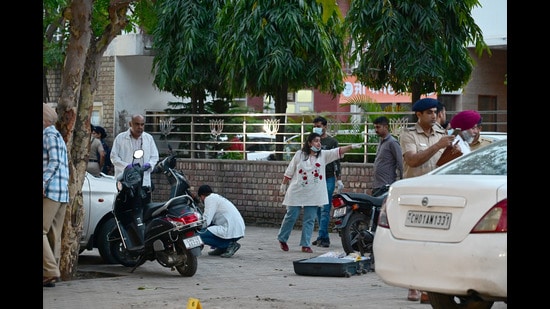 Forensic team along with Chandigarh police investigating the blast site outside the Punjab BJP office in Sector 37, Chandigarh, on Wednesday. (Ravi Kumar/HT)