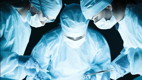 Medical team performing operation. Group of surgeon at work in operating theatre tonned in blue