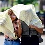 Prayagraj: People cover themselves while walking on a hot summer day, in Prayagraj, Uttar Pradesh, Sunday, March 29, 2026. (PTI Photo)(PTI03_29_2026_000058A)