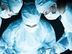 Medical team performing operation. Group of surgeon at work in operating theatre tonned in blue
