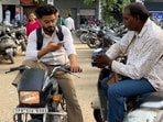A parking attendant issuing a ticket to a visitor at Feroze Gandhi Market in Ludhiana on Friday. (HT Photo)