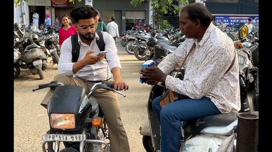 A parking attendant issuing a ticket to a visitor at Feroze Gandhi Market in Ludhiana on Friday. (HT Photo)