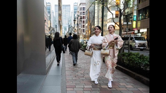Friends walk through a shopping area in Tokyo’s Ginza district (Andrew Caballero-Reynolds/AFP)