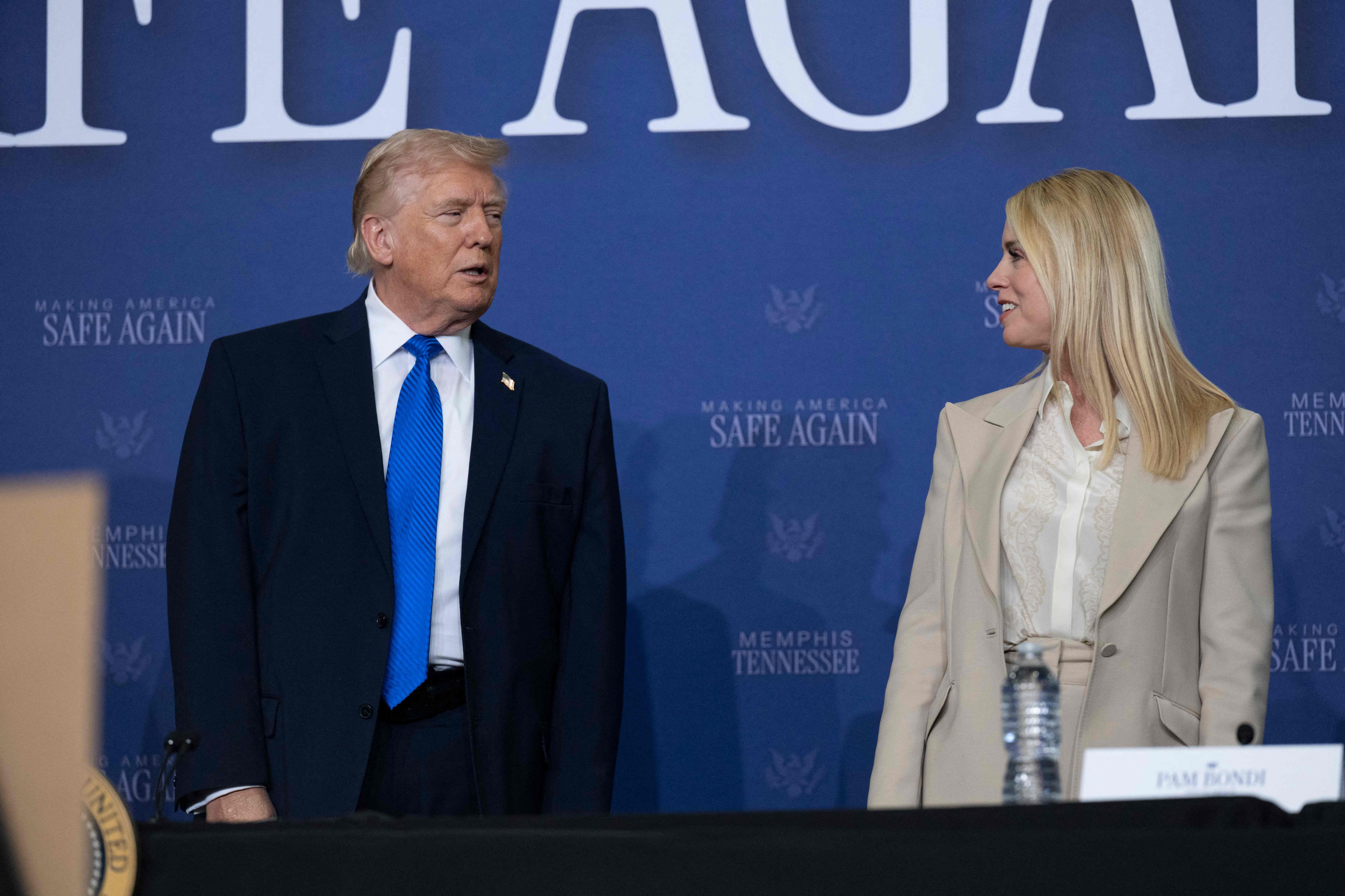President Donald Trump interacts with then U.S. General Attorney Pam Bondi as he took to the stage to participate in a roundtable discussion regarding the Memphis Safe Task Force (MSTF) in combating violent crime at the Memphis International Airport. (AFP) President Donald Trump interacts with then U.S. General Attorney Pam Bondi as he took to the stage to participate in a roundtable discussion regarding the Memphis Safe Task Force (MSTF) in combating violent crime at the Memphis International Airport. (AFP)