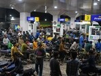 Motorcyclists crowd into a filling station as they wait their turn to buy fuel, in Karachi, Pakistan, Thursday, April 2