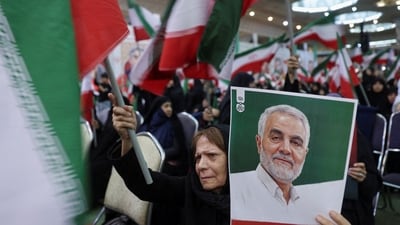 An Iranian woman holds a picture of  senior Iranian military commander General Qassem Soleimani during a ceremony to mark the sixth anniversary of his killing in a U.S. attack, in Tehran, Iran, January 1, 2026. (via REUTERS)