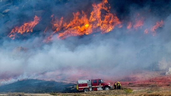 Pechanga Fire Department firefighters monitor the smoky and fast-growing wildfire Springs Fire in Moreno Valley, California, April 3. (Terry Pierson /The Orange County Register via AP)