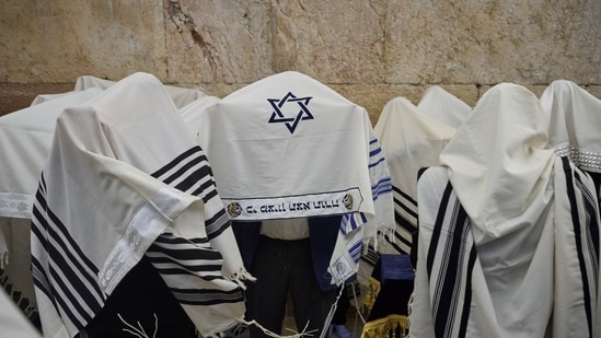 Ultra-Orthodox Jewish men pray during the priestly blessing on the Jewish holiday of Passover at the Western Wall, the holiest site where Jews can pray, in Jerusalem's Old City, largely empty due to restrictions linked to the Iran war, Sunday, April 5, 2026. (AP)