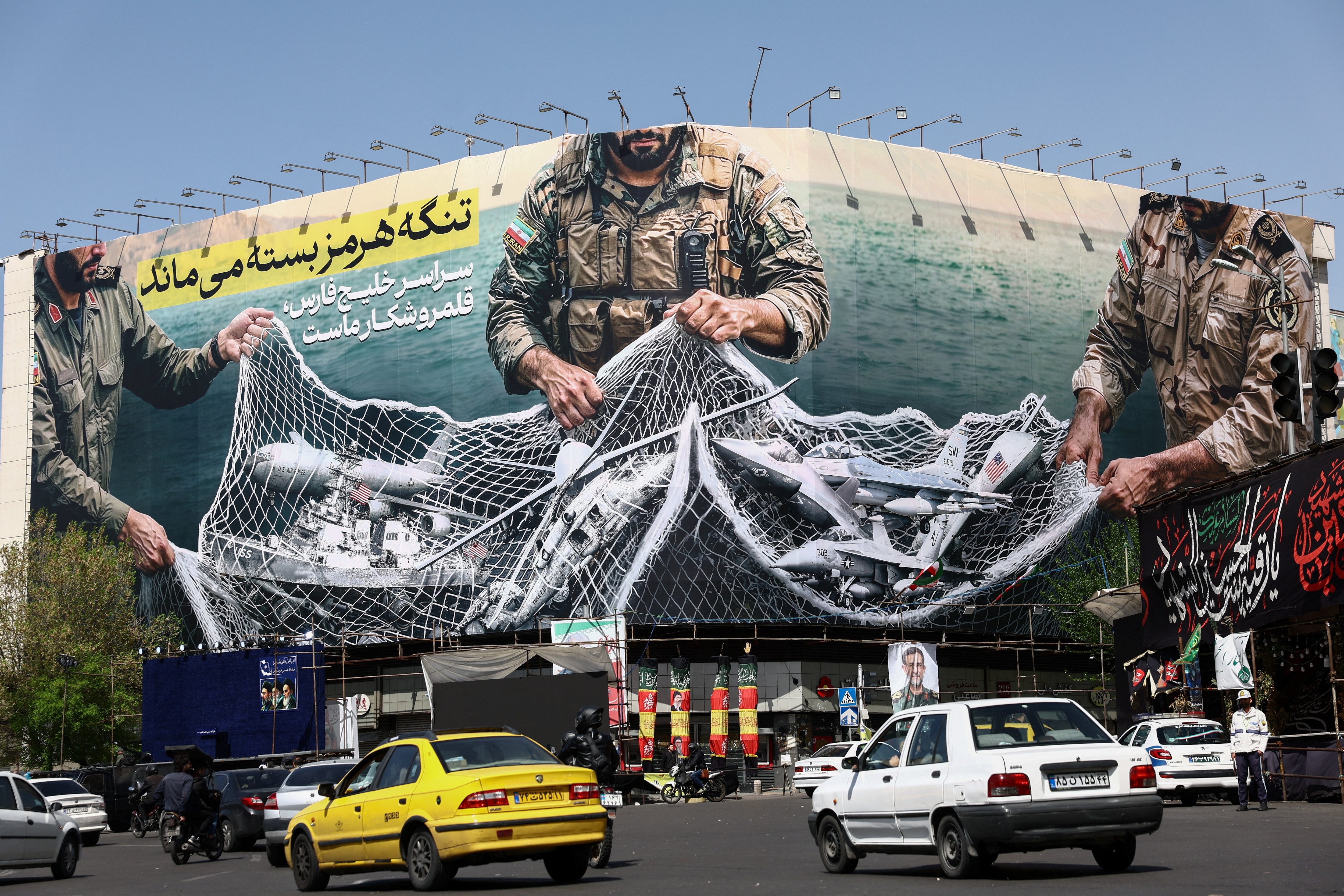 Cars drive near an anti-US billboard amid the US-Israeli conflict with Iran, in Tehran on April 5, 2026. (Majid Asgaripour/WANA via Reuters Photo)