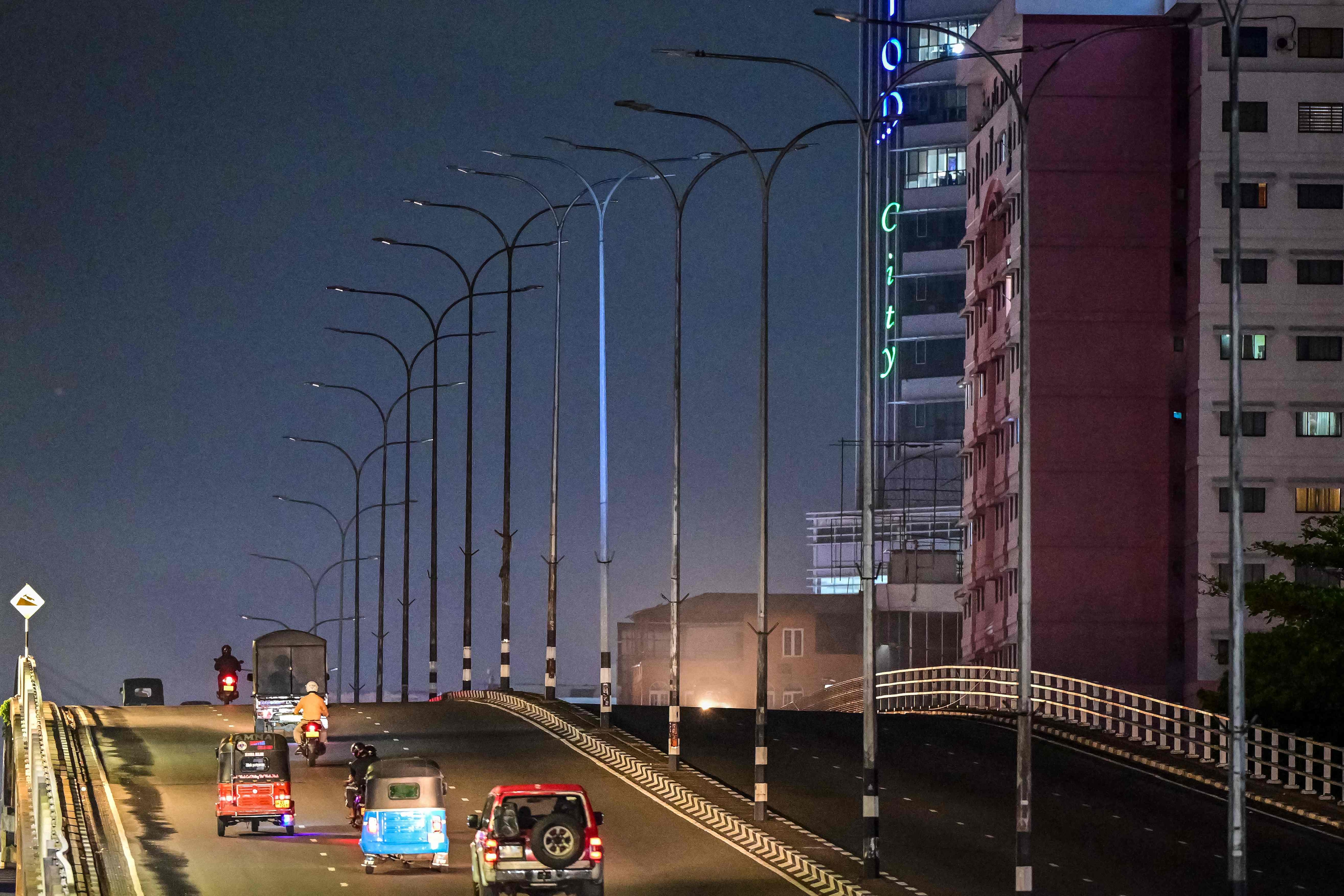 Vehicles move past switched-off street lights along a flyover in Colombo, Sri Lanka (AFP) Vehicles move past switched-off street lights along a flyover in Colombo, Sri Lanka (AFP)