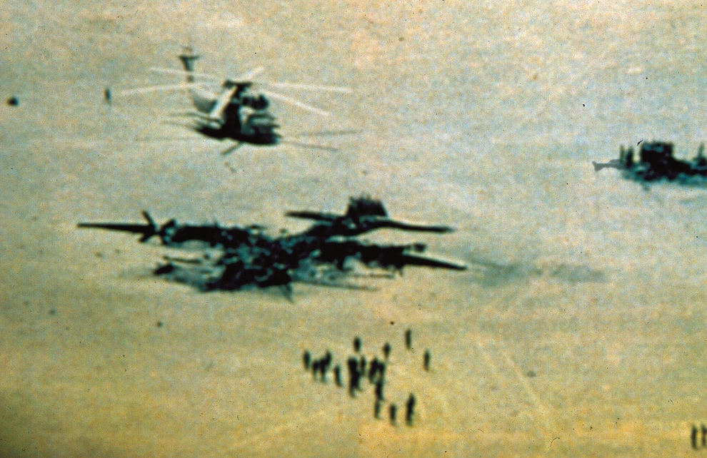 A photo of the 'Desert One' landing site, a piece of desert in Iran used by US forces as a refueling point in an attempt to rescue U.S. hostages in Iran. On April 24, 1980, a US Navy Sikorsky RH-53D Sea Stallion (seen on the right) collided with a a Lockheed EC-130E Hercules (wrecked, in the foreground) as the mission was aborted. Both aircraft were destroyed, eight US crewmen died. (Photo: USSOCOM) A photo of the 'Desert One' landing site, a piece of desert in Iran used by US forces as a refueling point in an attempt to rescue U.S. hostages in Iran. On April 24, 1980, a US Navy Sikorsky RH-53D Sea Stallion (seen on the right) collided with a a Lockheed EC-130E Hercules (wrecked, in the foreground) as the mission was aborted. Both aircraft were destroyed, eight US crewmen died. (Photo: USSOCOM)