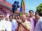Chief minister Yogi Adityanath takes a selfie with BJP MP Ravi Kishan and others on the occasion of 47th Foundation Day of the party, at Ramlila Maidan, in Gorakhpur, on Monday. (PTI Photo)