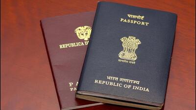 An Indian passport placed on top of a Colombian passport on a highly polished rosewood table. The passports are reflected on the polished wooden surface. The Indian passport has two booklets attached to each other denoting a much travelled holder. The holder obviously needed additional pages. The countries' details and emblems are in gold print on the documents' covers. Horizontal format. Copy space. (Getty Images/iStockphoto)