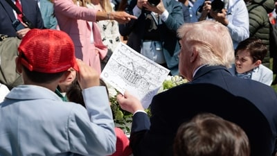 Trump holds a signed drawing as he hosts the annual Easter Egg Roll on the South Lawn of the White House on April 6, 2026, in Washington, DC. (Photo by Kent Nishimura / AFP) (AFP) Trump holds a signed drawing as he hosts the annual Easter Egg Roll on the South Lawn of the White House on April 6, 2026, in Washington, DC. (Photo by Kent Nishimura / AFP) (AFP)