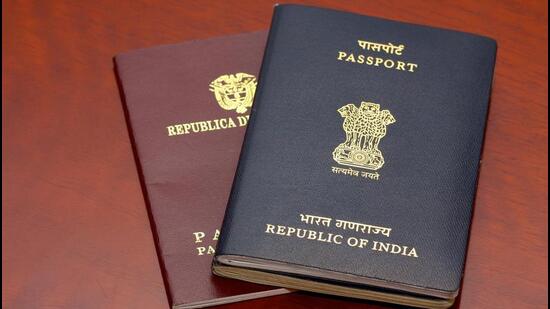 An Indian passport placed on top of a Colombian passport on a highly polished rosewood table. The passports are reflected on the polished wooden surface. The Indian passport has two booklets attached to each other denoting a much travelled holder. The holder obviously needed additional pages. The countries' details and emblems are in gold print on the documents' covers. Horizontal format. Copy space. (Getty Images/iStockphoto)