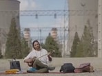 The Iranian musician Ghamsari plays in front of a power plant, civilian infrastructure whose destruction is threatened by Trump.