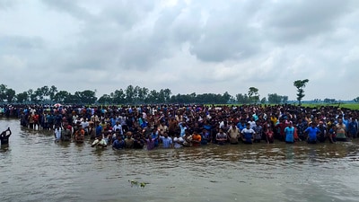 Bangladeshi nationals assemble close to the Sitalkuchi fenced land border in Cooch Behar in their bid to crossover to India. (PTI File) Bangladeshi nationals assemble close to the Sitalkuchi fenced land border in Cooch Behar in their bid to crossover to India. (PTI File)
