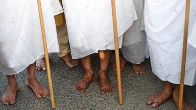 TOPSHOT - Indian Jains Sanjaybhai Shah (L), his son Darshil Shah (C), and Dharmeshbhai Shah (R) stand together after a ceremony where they renounced their material lifestyles to become Jain monks on the outskirts of Ahmedabad on April 25, 2018. Six women and three men from wealthy families undertook rituals on April 25 as part of a ceremony to become Jain nuns and monks, while being watched by a large Jain congregation. Strict Jain devotees renounce the material world, become vegans and follow a code of non-violence against all living things. / AFP PHOTO / SAM PANTHAKY (AFP)
