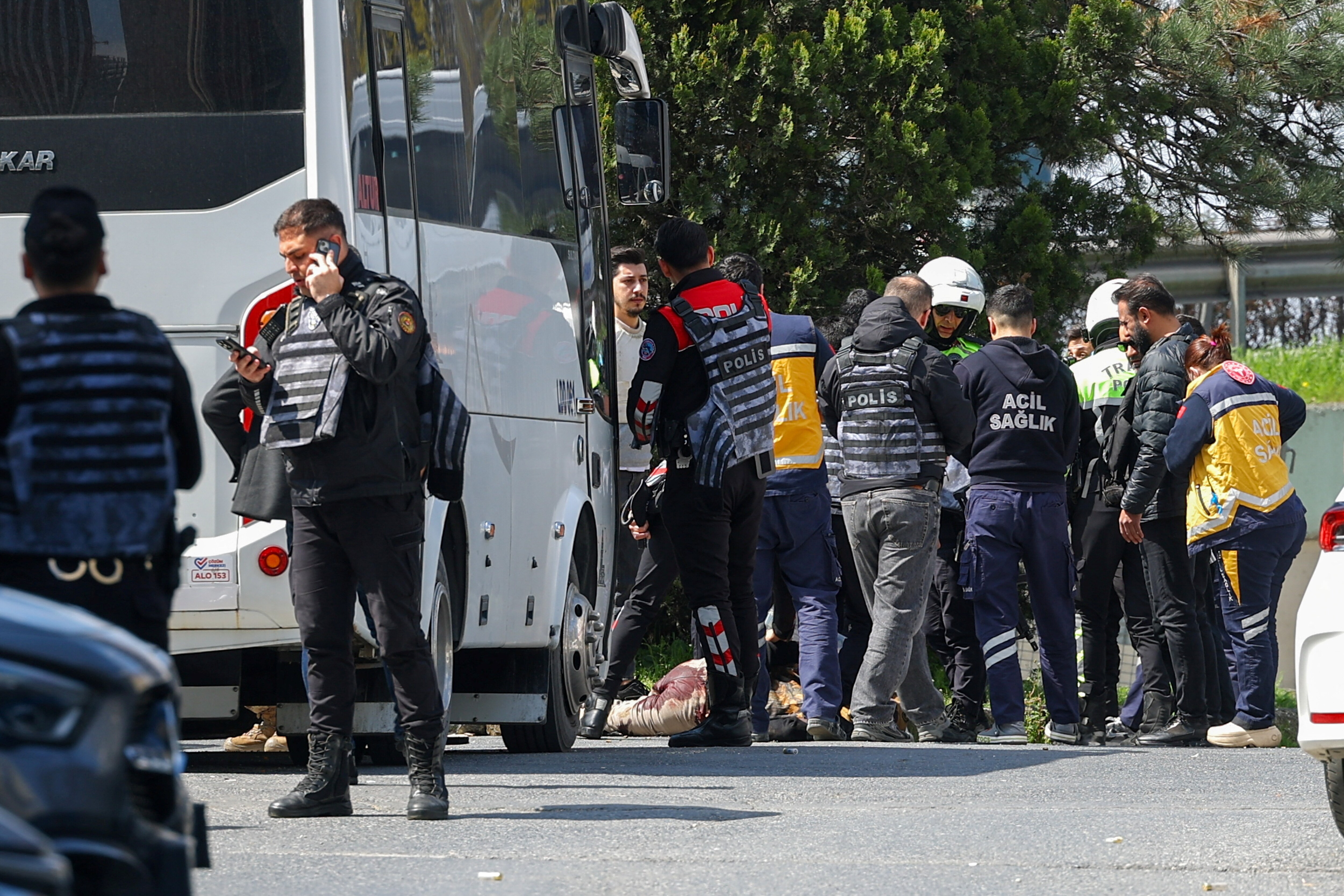 Graphic content warning: Police stand next to a wounded person, believed to be the attacker, after gunfire was heard near the building housing the Israeli consulate (REUTERS)