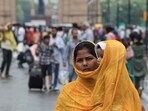 A woman covers her child with her shawl amid rain in New Delhi on Tuesday. .