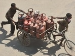 Delivery persons transporting LPG gad cylinders in a rickshaw cart in Patna. (HT Photo) Delivery persons transporting LPG gad cylinders in a rickshaw cart in Patna. (HT Photo)