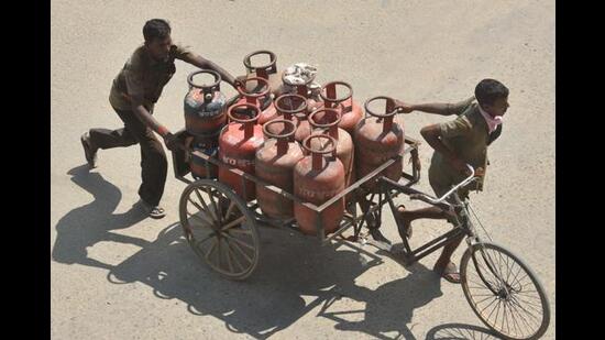 Delivery persons transporting LPG gad cylinders in a rickshaw cart in Patna. (HT Photo)