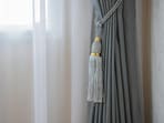 Light cotton and sheer curtains filter sunshine through an open window, instantly giving the room a breezy summer feel.