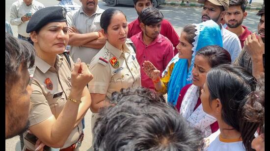 Police personnel seen with protesting workers on Thursday. (Parveen Kumar/HT)