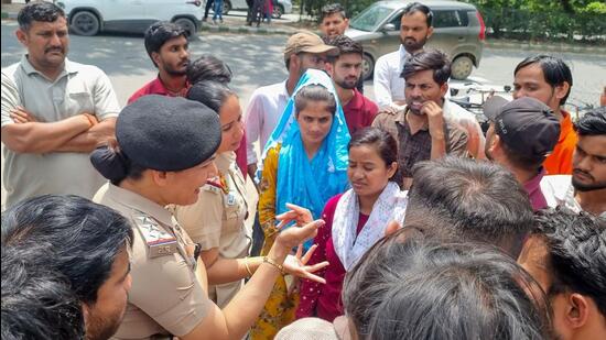 Workers seen along with police personnel during the protest on Thursday. (Parveen Kumar/HT)